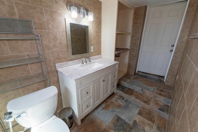 2935 NW Grand Blvd, Oklahoma City, OK 73116 - bathroom featuring toilet, tile walls, stone tile flooring, and vanity