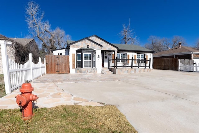 2935 NW Grand Blvd, Oklahoma City, OK 73116 - view of front of house featuring a gate, stone siding, and fence