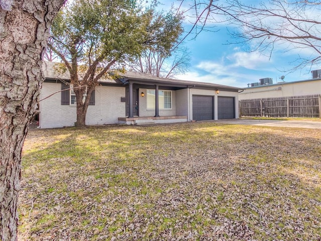 2832 Warwick Dr, Oklahoma City, OK 73116 - ranch-style home featuring a front lawn, fence, concrete driveway, an attached garage, and brick siding