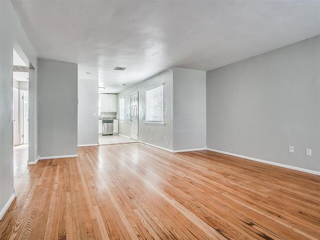 2832 Warwick Dr, Oklahoma City, OK 73116 - unfurnished living room featuring visible vents, light wood-style flooring, and baseboards