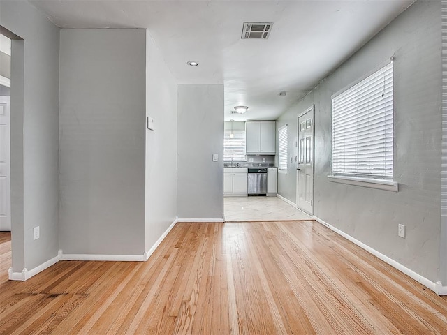 2832 Warwick Dr, Oklahoma City, OK 73116 - unfurnished living room featuring a sink, visible vents, baseboards, and light wood-style flooring