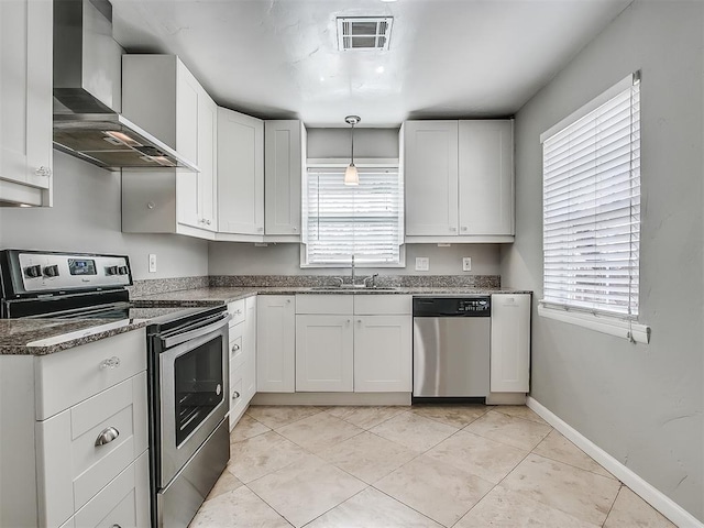 2832 Warwick Dr, Oklahoma City, OK 73116 - kitchen featuring visible vents, a healthy amount of sunlight, appliances with stainless steel finishes, wall chimney exhaust hood, and a sink