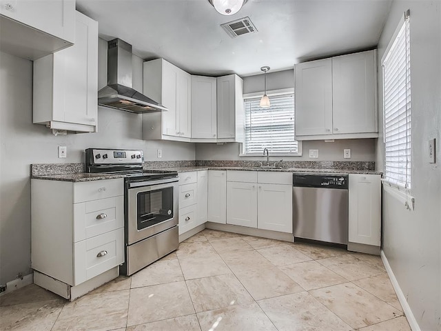 2832 Warwick Dr, Oklahoma City, OK 73116 - kitchen with a wealth of natural light, visible vents, appliances with stainless steel finishes, and wall chimney range hood
