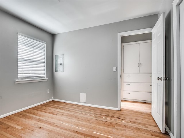 2832 Warwick Dr, Oklahoma City, OK 73116 - unfurnished bedroom featuring electric panel, light wood-type flooring, and baseboards