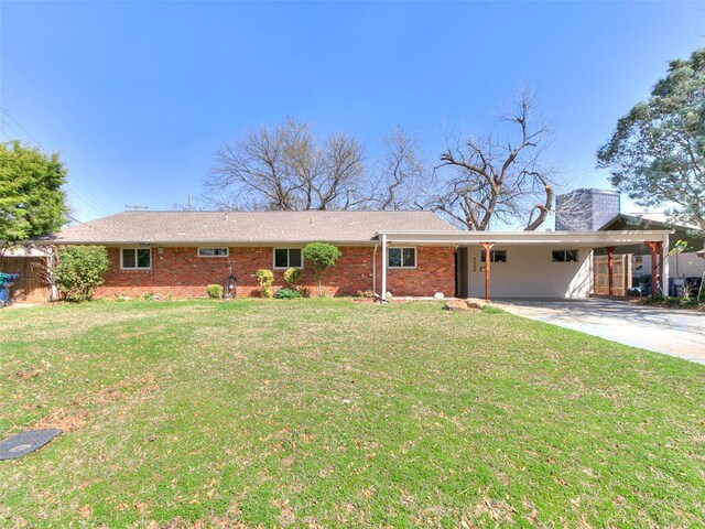 ranch-style house with an attached carport, concrete driveway, and a front yard