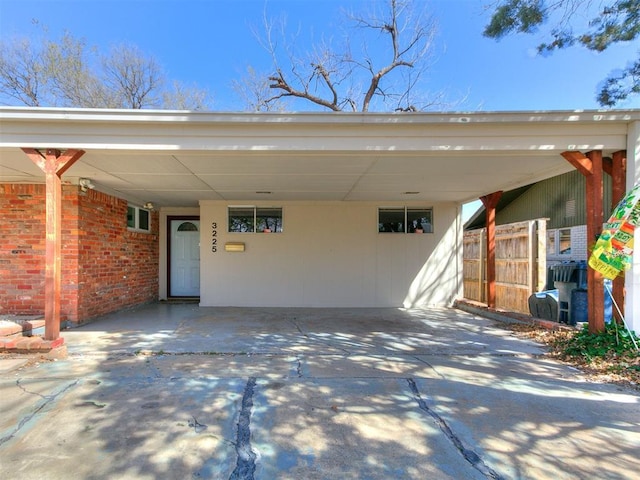 exterior space featuring a carport, concrete driveway, and brick siding