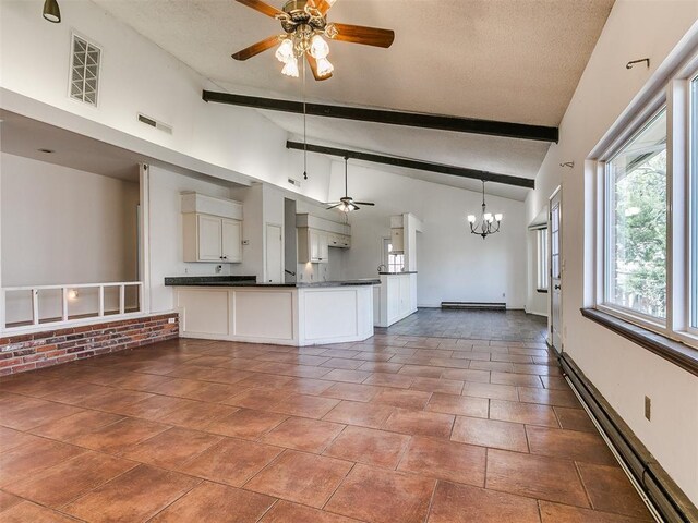 kitchen featuring visible vents, ceiling fan with notable chandelier, dark countertops, open floor plan, and a peninsula