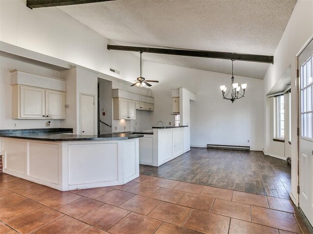 kitchen featuring dark countertops, baseboard heating, a peninsula, and a textured ceiling