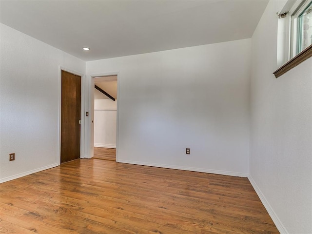 unfurnished room featuring recessed lighting, baseboards, and wood finished floors
