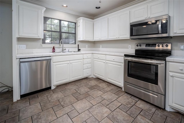 4505 N Peniel Ave, Bethany, OK 73008 - kitchen featuring appliances with stainless steel finishes, tile counters, white cabinets, stone finish flooring, and crown molding