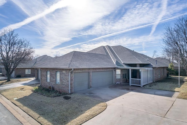 ranch-style home with a garage, brick siding, roof with shingles, and concrete driveway