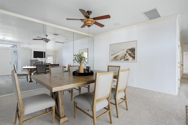 carpeted dining area with visible vents, ceiling fan, and ornamental molding