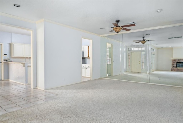 unfurnished bedroom with visible vents, light carpet, a brick fireplace, and ornamental molding