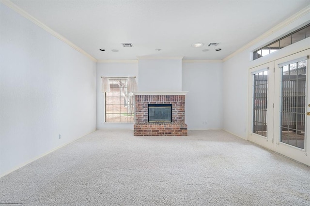 unfurnished living room featuring crown molding, a brick fireplace, carpet, and visible vents