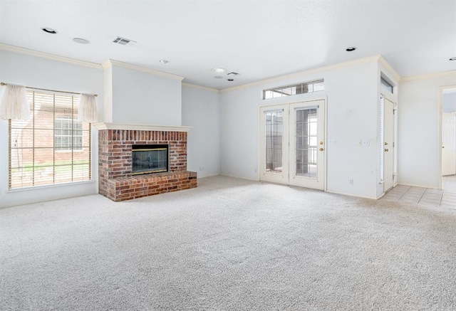 unfurnished living room featuring crown molding, a brick fireplace, visible vents, and carpet floors
