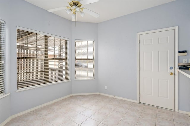 unfurnished room with light tile patterned flooring, baseboards, and ceiling fan