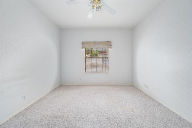 carpeted empty room featuring a ceiling fan and baseboards