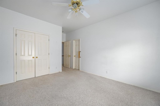 unfurnished bedroom with a ceiling fan, light colored carpet, and a closet