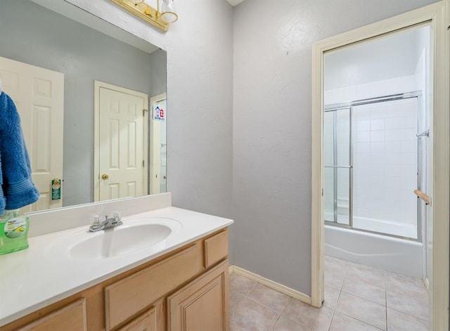 full bath with tile patterned flooring, combined bath / shower with glass door, vanity, and baseboards
