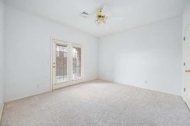unfurnished room with carpet, visible vents, and ceiling fan