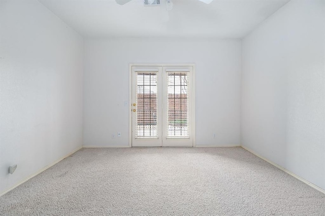 empty room featuring baseboards, ceiling fan, and carpet floors