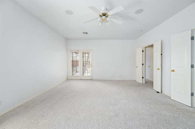 spare room featuring visible vents, light colored carpet, and ceiling fan