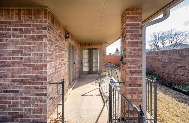 view of patio featuring a balcony and fence
