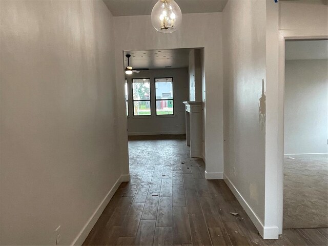 hall featuring baseboards and dark wood finished floors