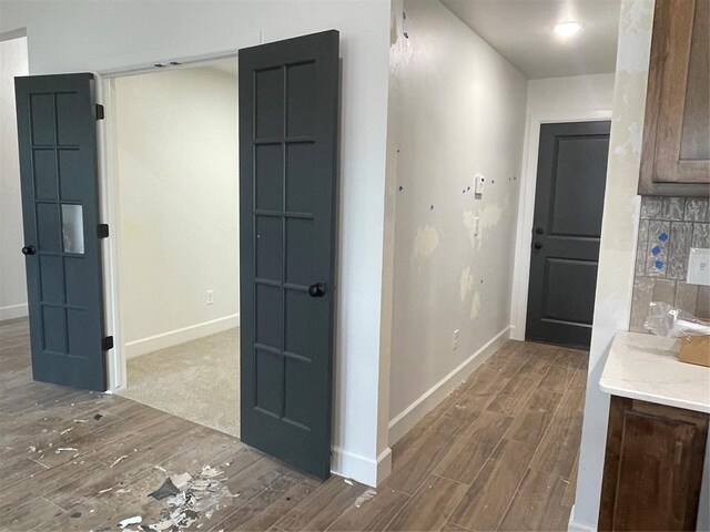 hallway featuring baseboards and wood finished floors