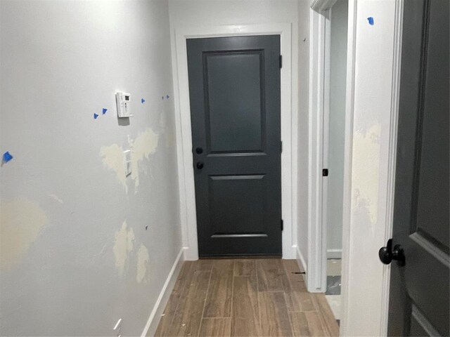 doorway to outside featuring baseboards and wood finished floors