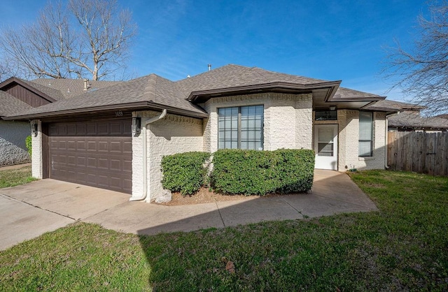 3833 Ives Way, Norman, OK 73072 - view of front of house with an attached garage, a shingled roof, driveway, and brick siding