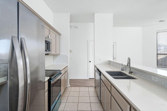 3833 Ives Way, Norman, OK 73072 - kitchen with appliances with stainless steel finishes, a sink, light countertops, light tile patterned floors, and backsplash