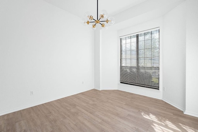 3833 Ives Way, Norman, OK 73072 - empty room with wood finished floors, a chandelier, and baseboards