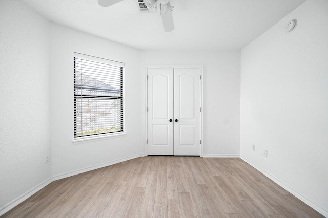 3833 Ives Way, Norman, OK 73072 - unfurnished bedroom with wood finished floors, a closet, baseboards, and ceiling fan