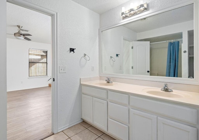 3833 Ives Way, Norman, OK 73072 - bathroom featuring a textured wall, a textured ceiling, double vanity, baseboards, and curtained shower