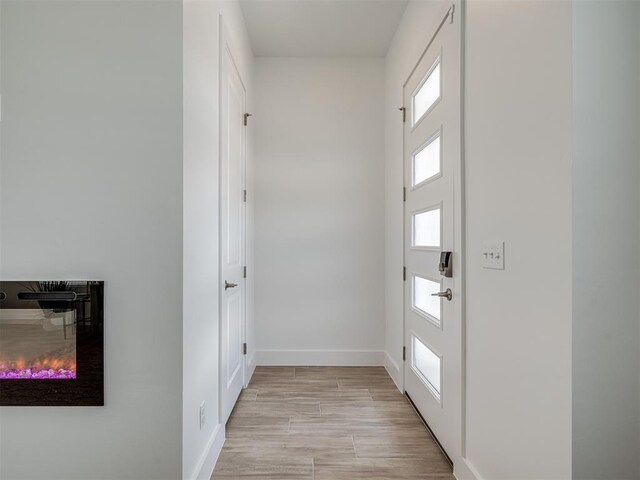 13112 Maplewood Ave, Oklahoma City, OK 73120 - doorway with baseboards, healthy amount of natural light, and light wood finished floors
