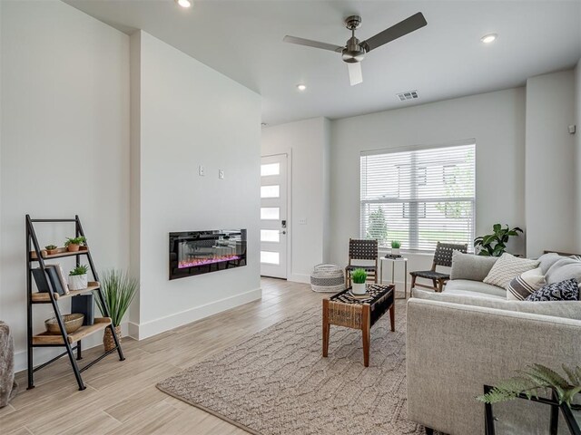 13112 Maplewood Ave, Oklahoma City, OK 73120 - living room featuring light wood-type flooring, ceiling fan, recessed lighting, a glass covered fireplace, and baseboards