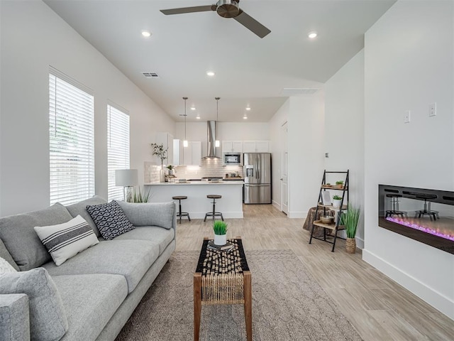 13112 Maplewood Ave, Oklahoma City, OK 73120 - living area featuring light wood-type flooring, a ceiling fan, recessed lighting, baseboards, and a glass covered fireplace