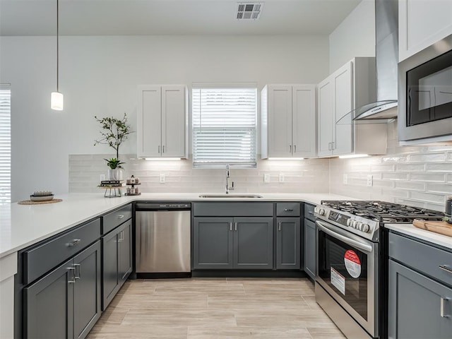 13112 Maplewood Ave, Oklahoma City, OK 73120 - kitchen featuring appliances with stainless steel finishes, a sink, wall chimney range hood, and gray cabinets
