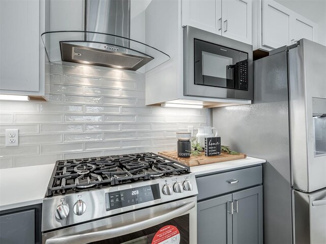 13112 Maplewood Ave, Oklahoma City, OK 73120 - kitchen featuring appliances with stainless steel finishes, island exhaust hood, light countertops, tasteful backsplash, and gray cabinets