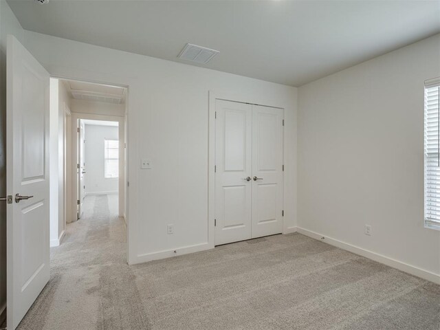 13112 Maplewood Ave, Oklahoma City, OK 73120 - unfurnished bedroom with light colored carpet, baseboards, attic access, and a closet