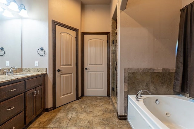 full bath featuring a tub with jets, vanity, a shower stall, and stone finish floor