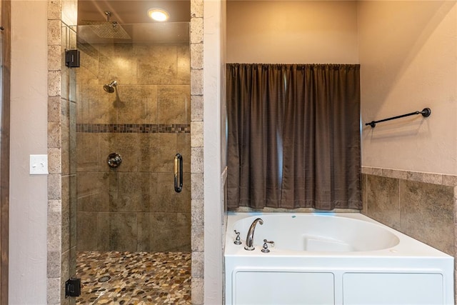 bathroom featuring a shower stall and a garden tub