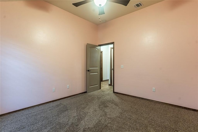 carpeted empty room featuring baseboards, ceiling fan, and visible vents