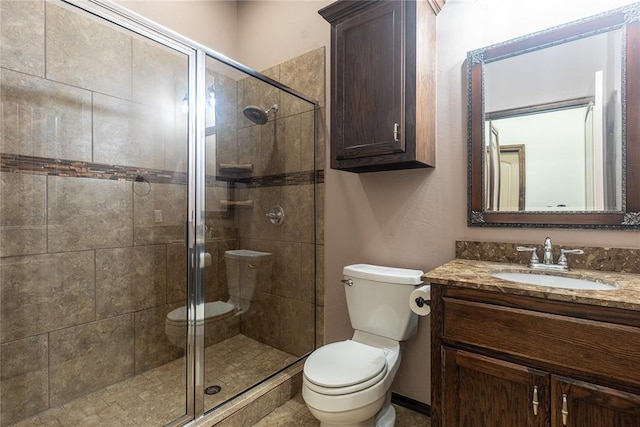 bathroom with toilet, vanity, and a stall shower