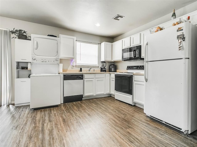 1419 NW 98th St, Oklahoma City, OK 73114 - kitchen with visible vents, white appliances, white cabinets, and stacked washing maching and dryer