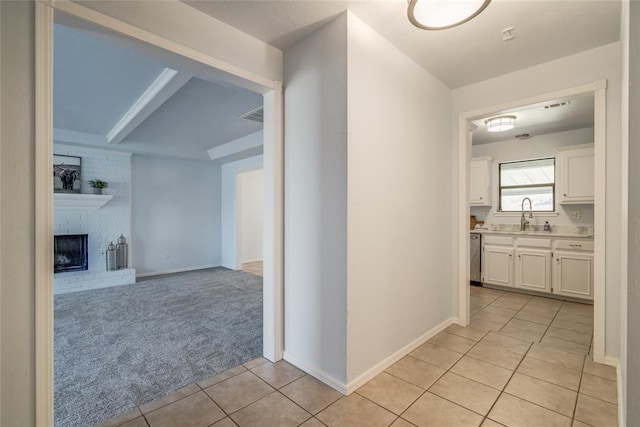 2408 Cypress Ct, Edmond, OK 73013 - hall with light tile patterned floors, light colored carpet, baseboards, and a sink