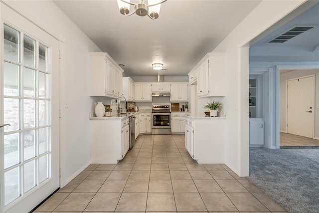 2408 Cypress Ct, Edmond, OK 73013 - kitchen with stainless steel appliances, under cabinet range hood, light countertops, and light tile patterned flooring