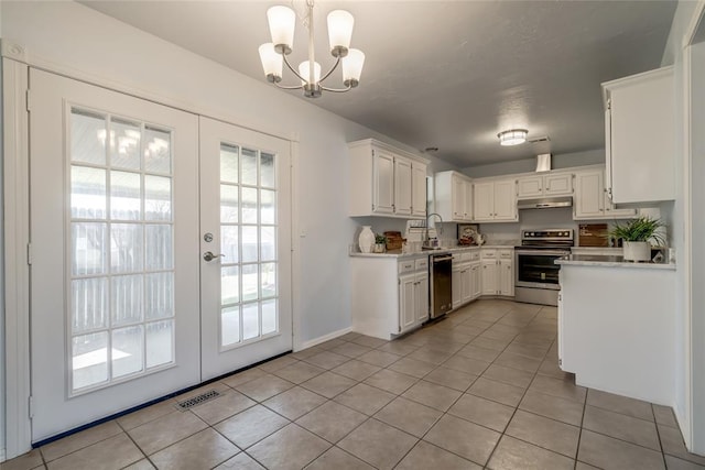 2408 Cypress Ct, Edmond, OK 73013 - kitchen featuring stainless steel appliances, under cabinet range hood, light tile patterned floors, light countertops, and a chandelier