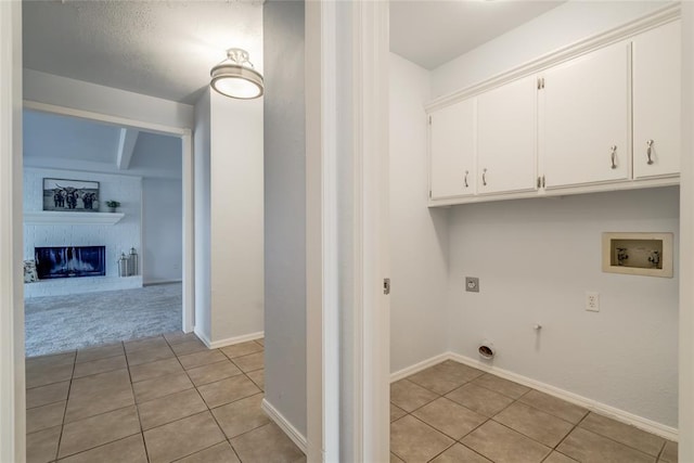 2408 Cypress Ct, Edmond, OK 73013 - laundry area featuring cabinet space, light tile patterned floors, gas dryer hookup, hookup for an electric dryer, and washer hookup